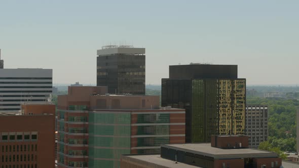 Aerial view of the tops of city buildings in downtown Clayton, Missouri in St. Louis, camera pans.