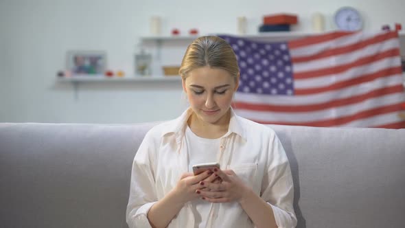 Joyful Woman Chatting on Smartphone, US Flag on Background, Communication
