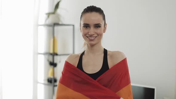 Portrait Young Woman Wearing LGBT Flag Standing at Home. She Looking Into the Camera, Smiling.
