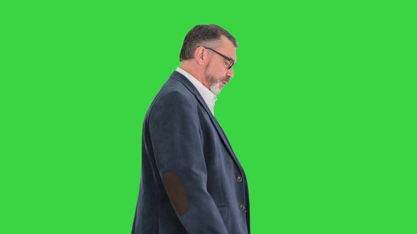 Mature Business Man Consulting His Watch on a Green Screen Chroma Key