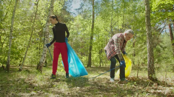 Active Eco Friendly Adult Couple Cleaning Forest From Litter