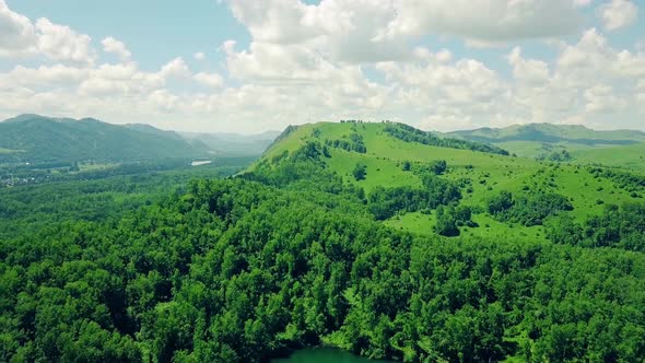 Aerial Flying Back Over Mountains and the Forest Under the Cloudy Sky