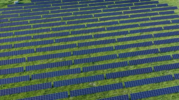 Aerial view on Solar Power Station in Green Field near River at Sunny Day