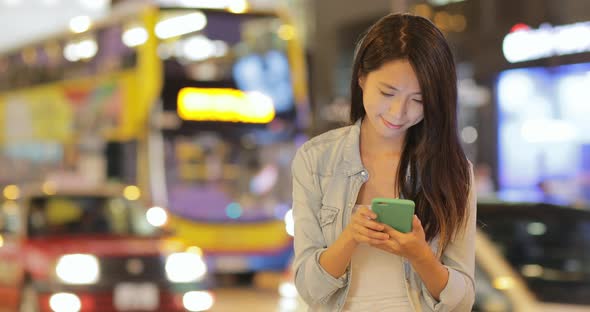 Woman using cellphone at night 