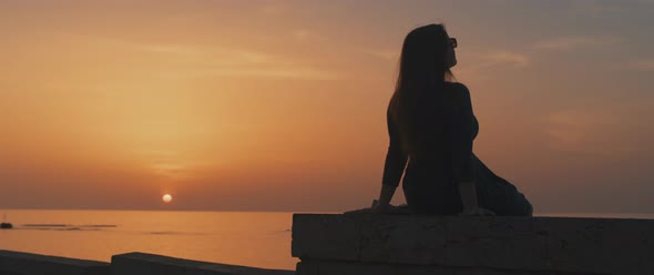 Silhouette of woman watching sunset