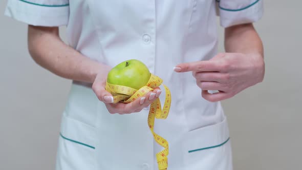 Nutritionist Doctor Healthy Lifestyle Concept - Holding Organic Green Apple and Measuring Tape