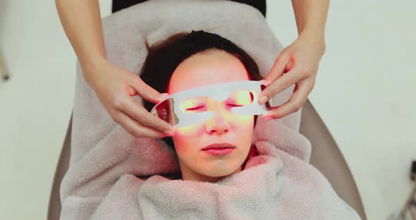 The Woman Is Wearing LED Glasses To Remove Wrinkles