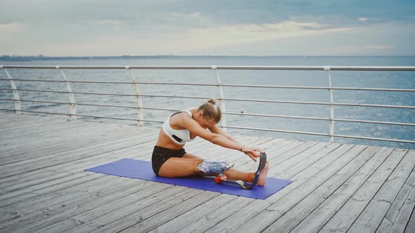 Young Disabled Woman Training Alone on Pier Near Sea