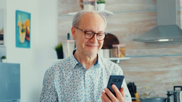 Elderly Man Smiling with Phone in Hands
