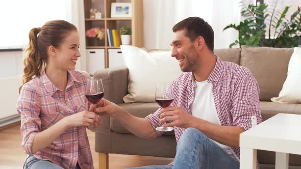 Happy Couple Drinking Red Wine at Home