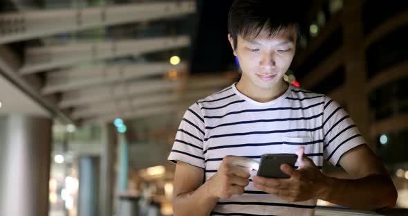 Young man use of mobile phone in the city 