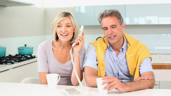 Couple Talking On The Telephone Together