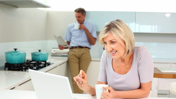 Woman Using Laptop While Her Husband Is Standing