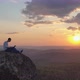 A Young Man Works on a Laptop Outdoors on a Mountaintop at Sunset. - VideoHive Item for Sale