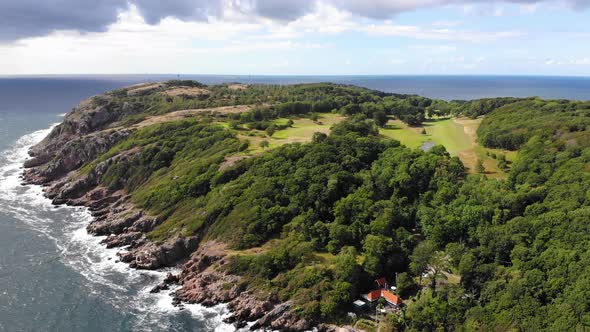 Rugged coastal peninsula of Kullaberg on sunny day with visible horizon, aerial