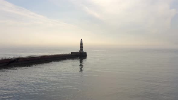 A Lighthouse and Pier in the Early Morning