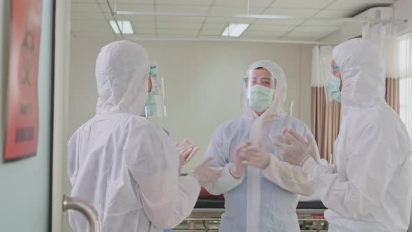 Group of Asian doctors in PPE suit feeling glad after success working in Hospital emergency room.