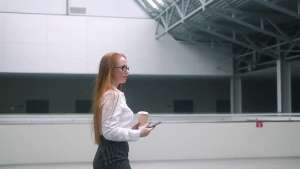 Confident woman  walks inside  lobby of the business center