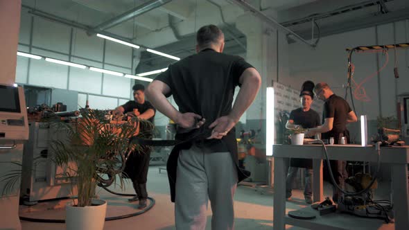 The beginning of the work shift at the plant. A factory worker wears a protective apron