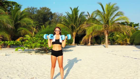 Beautiful smiling ladies on photoshoot in the sun at the beach on clean white sand and blue 