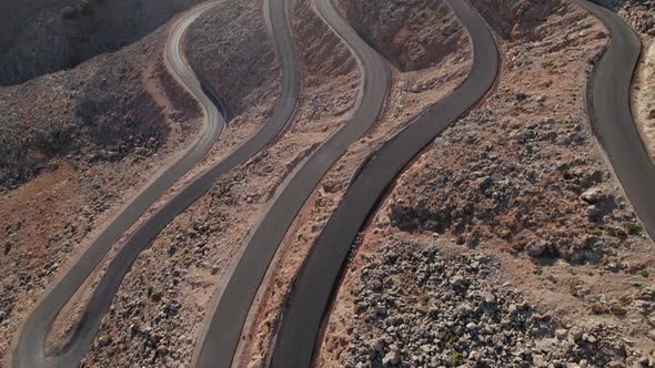 Aerial drone 4K footage of a curved rocky road. Motorway through mountains next to a precipice