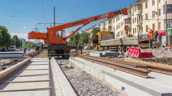 Orange Construction Telescopic Mobile Crane Unloading Tram Rails From Truck Timelapse