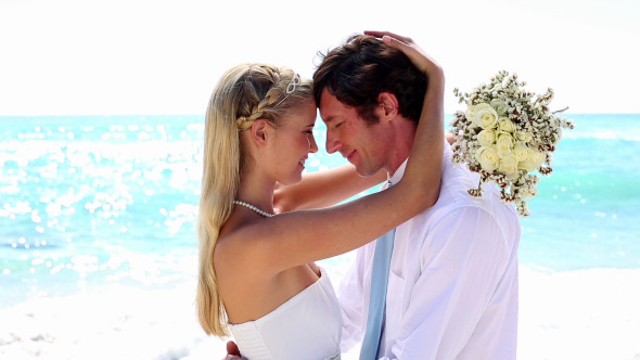 Newlyweds Embracing On The Beach