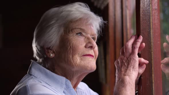 Woman leaning against window at home 