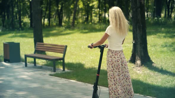 Woman Ride On Electric Scooter Mobility.E-Scooter Rider Rent Personal Eco Transport. Eco Transport.