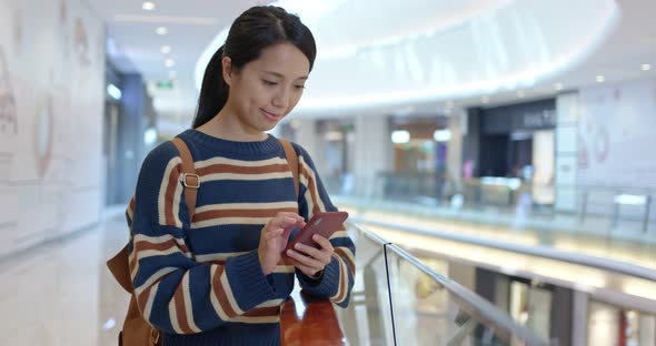 Woman look at smart phone inside shopping mall