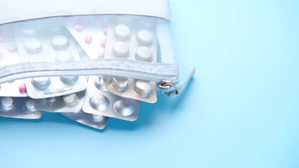 Close Up of Pills of Blister Pack in a Small Bag on Blue Background