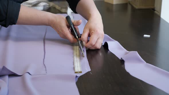 Tailor Cuts Cloth Uses Scissors Follow Chalk Markings of Pattern, Closeup Hands.