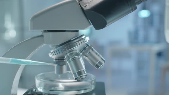 Black Scientist in Protective Wear Examining Chemical through Microscope