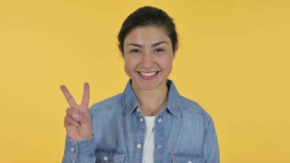 Victory Sign By Indian Woman, Yellow Background