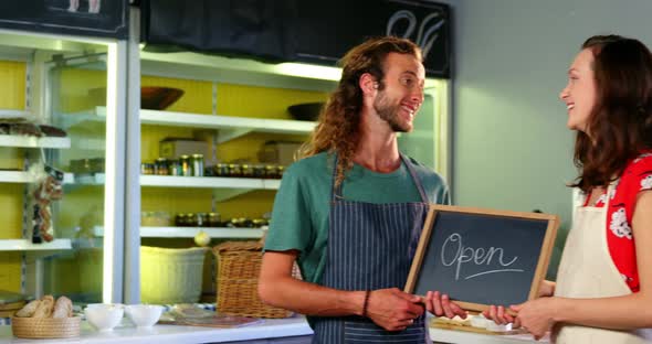 Portrait of workers holding a open sign