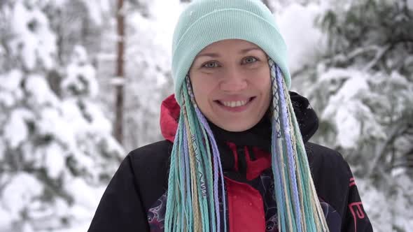 Portrait of a Happy Woman in Winter Clothes on the Background of Nature