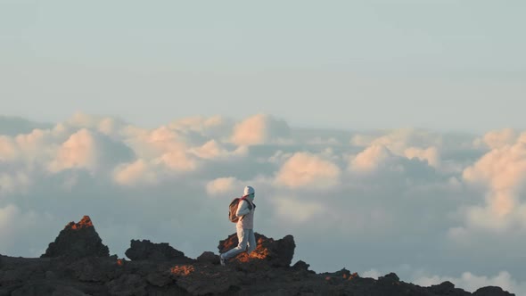 Traveler Exploring High Mountain Summit Above Clouds at Sunset Slow Motion