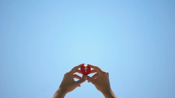 Male Hands Holding Heart Toy Against Sky, Help to Cardiac Patients, Charity