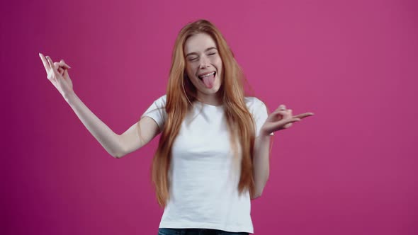 The Smiling Charismatic Young Woman Monkeys Around the Room Shows Her Tongue Rock Signs and Performs