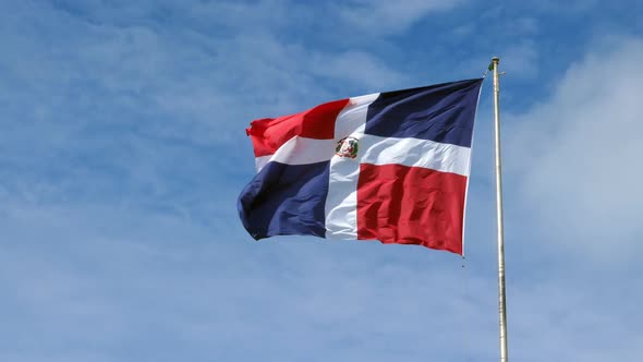 Flying and Waving Flag of Dominican Republic on Blue Sky Background