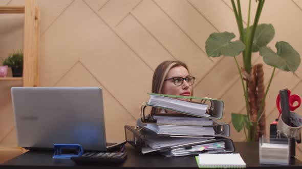 Female Office Worker is Sitting at Desk in Front of Lot of Folders with Documents Human Hands Put