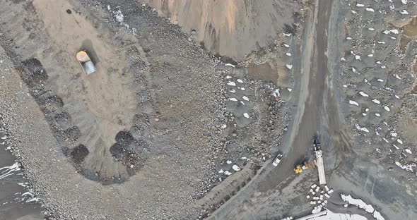 Aerial View of the Open Pit Loader Loading Gravel Into Stone Jaw Crusher in Openpit Quarry