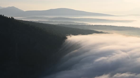 Tranquil Scene of Morning Haze Clouds Clowly Drifting in a Valley