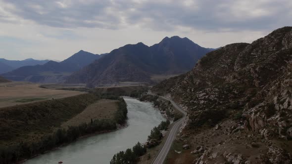 Mountains valley of Altai with blue Katun river under dramatic sky