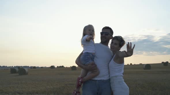 Portrait of Happy Family with Their Lovely Daughter Waving Their Palms