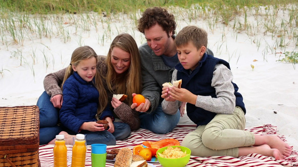 Happy Family Having A Picnic On The Beach