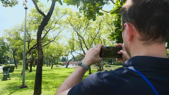 Male Travel Blogger Recording Video on Mobile Phone Standing in Nature