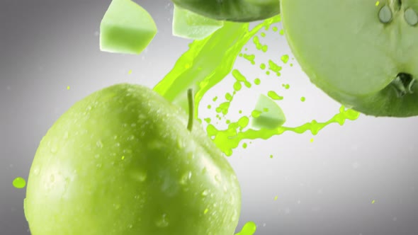 Green Apple with Slices Falling on Dark Grey Background