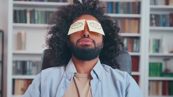 Tired Young Arabian Man Sleeps Working with Paper Stickers in Front of Eyes