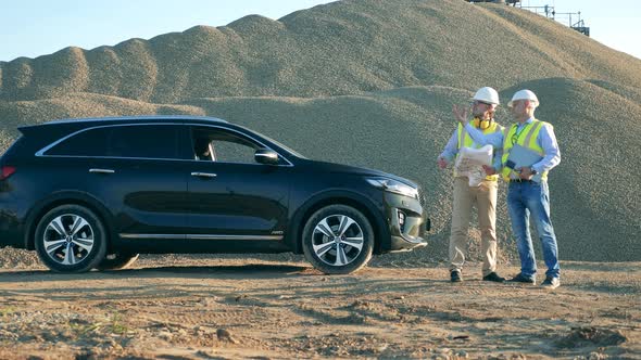 Experts Are Talking in the Quarry Next To a Car